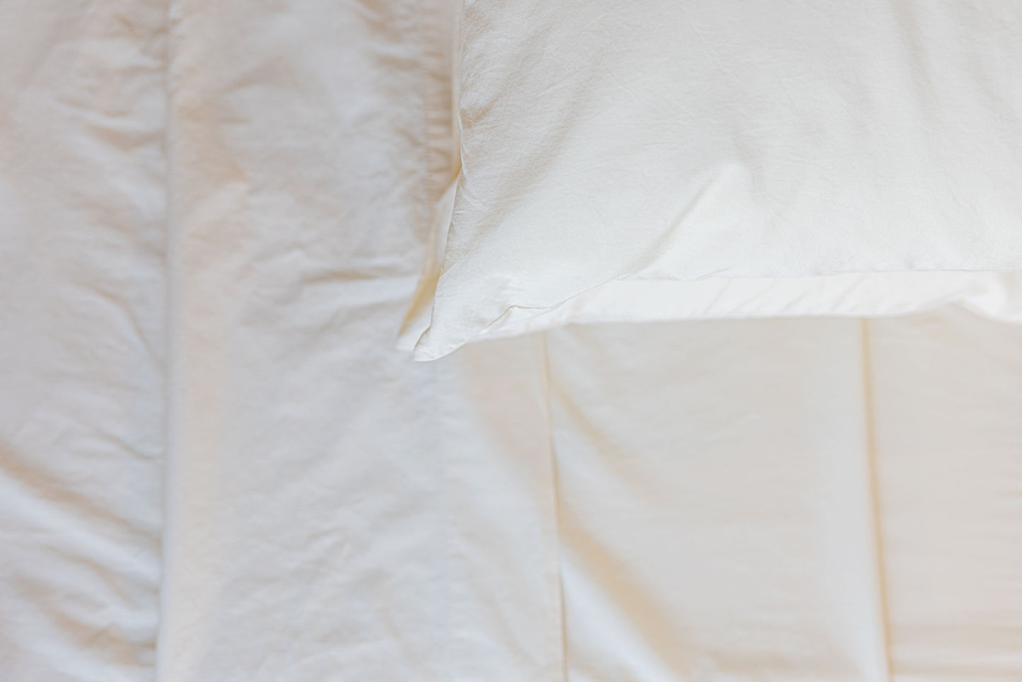 Close up of the corner of a pillowcase on a folded sheet.