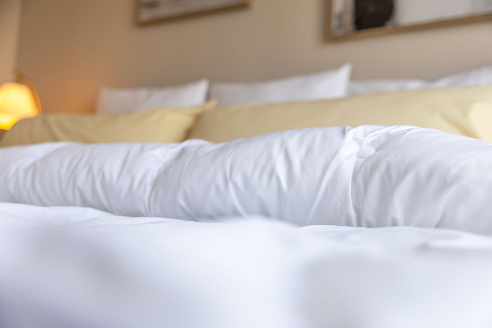 White split comforter on a bed with a blurred background