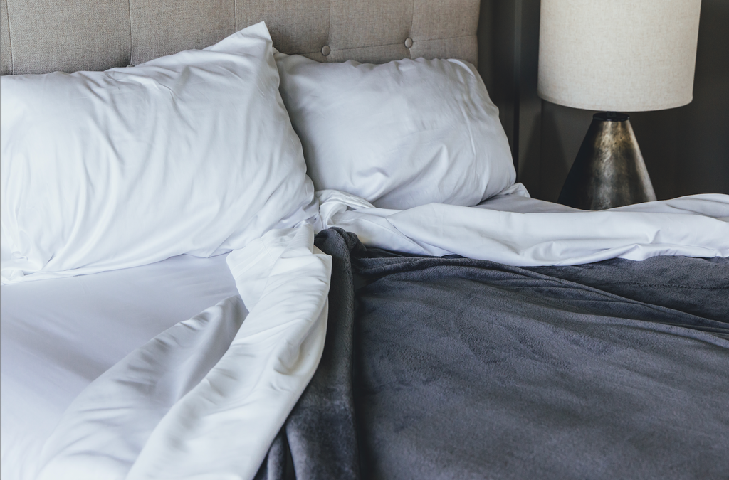 Bed showcasing blanket and sheets turned down
