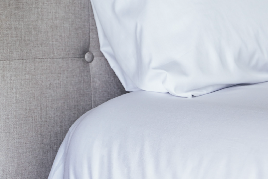 Corner of bed and pillow showcase sheets close up