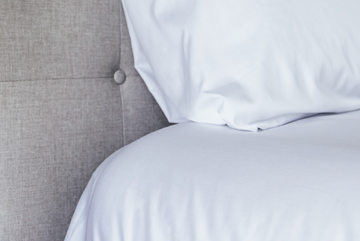 Corner of bed and pillow showcase sheets close up